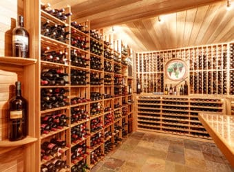 Bright home wine cellar with wooden storage units with bottles.